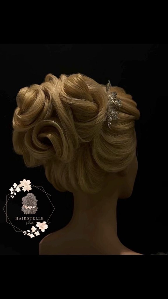 Creative blonde updo on dark background by Hairstelle