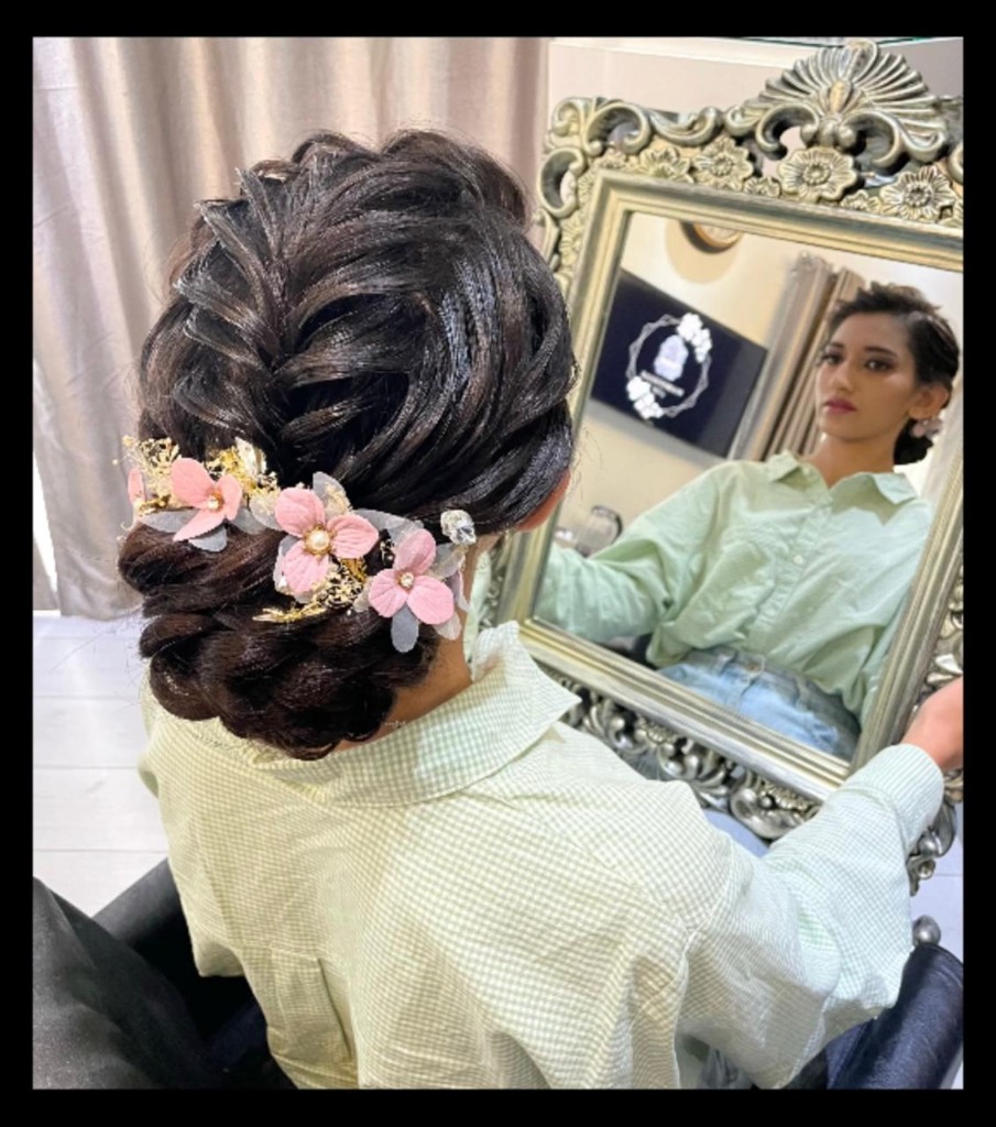 Brunette bridal updo with pink floral pins by Hairstelle